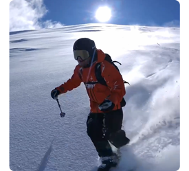Snowboarder with selfie stick removed riding down mountain with wide field of view