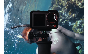 underwater photograph of diver holding DJI osmo action 5 pro recording video