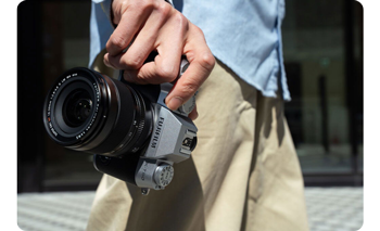 image of person walking carrying fujifilm X-T50 camera with XF16-50mm lens 