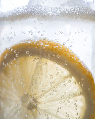 XF16-50mm sample macro image of carbonated bubbles floating in glass with slice of lemon