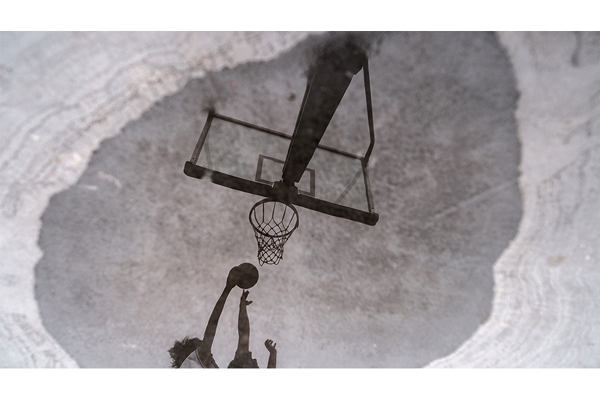 XF18mm F1.4 R LM WR sample photograph of puddle reflection showing two people jumping towards basketball hoop with ball