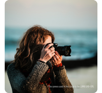 image of female photographer holding panasonic lumix camera standing taking photograph