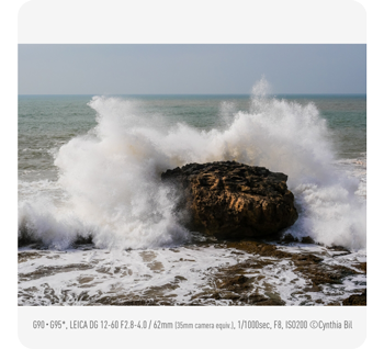 photograph of waves crashing over rock on seaside beachfront