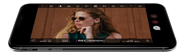 Apple iPhone with Accsson SEE app recording video of female presenter in front of wood panelling