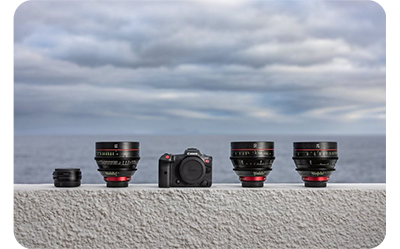 canon r5 c and a selection of capatible lenses on a grey wall with the sea in the background