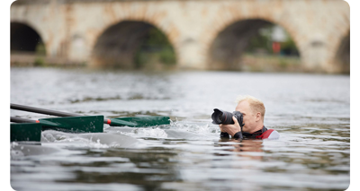 someone in a lake taking a photo of a boat using the canon rf 24 on their camera