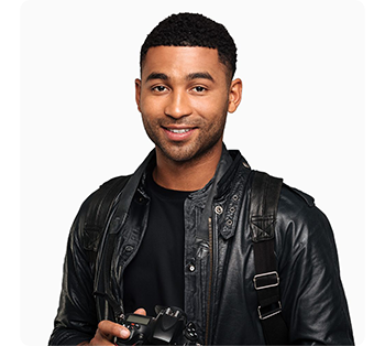 Young male photographer holding camera wearing black tee shirt and leather jacket