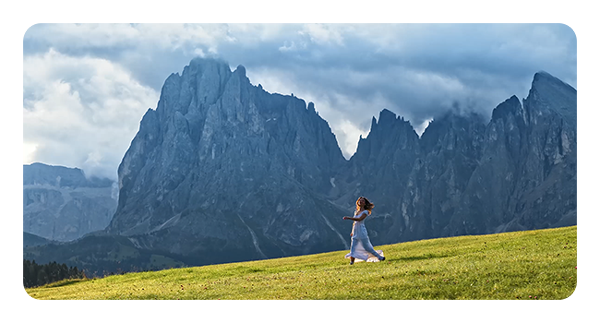 example image taken with the dji air 3s of a woman running through a field in front of a mountain