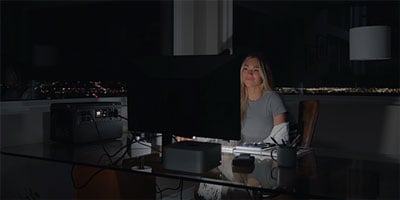someone using a pc connected to the dji power 1000 v2 portable power station during a power cut