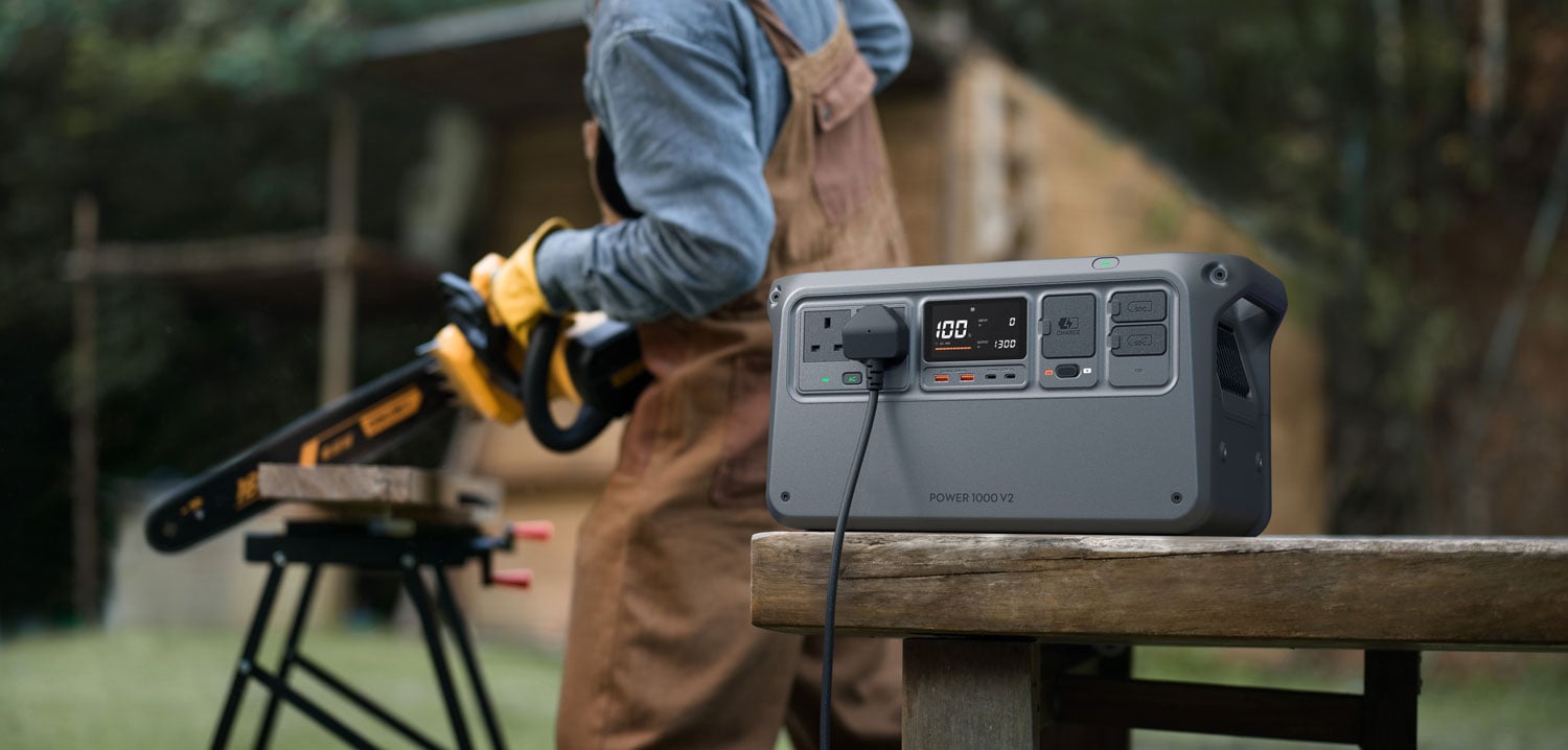 someone using a chainsaw connected to the dji power 1000 v2 portable power station