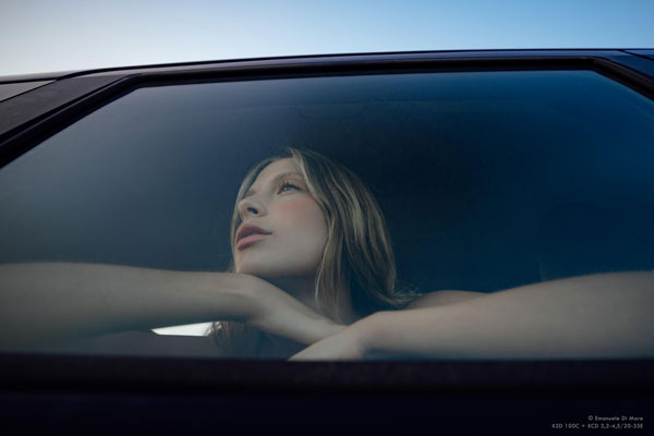 portrait photo of blonde woman sitting behind car window looking 