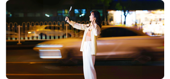 photograph of woman standing in street with smartphone 
