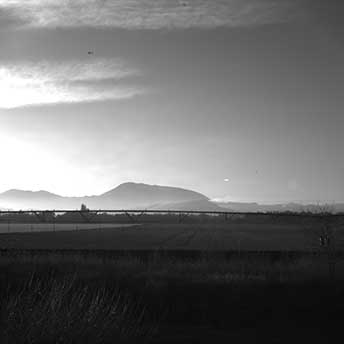 greyscale image of Oregon landscape showing flat farmland and mountain peak