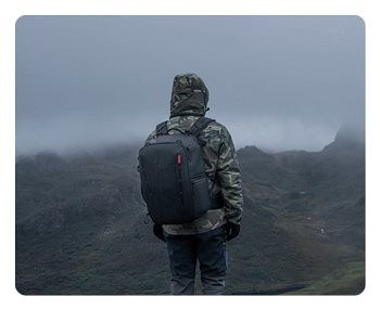 someone stood on a misty mountain top with the pgytech onemo 2 camera backpack
