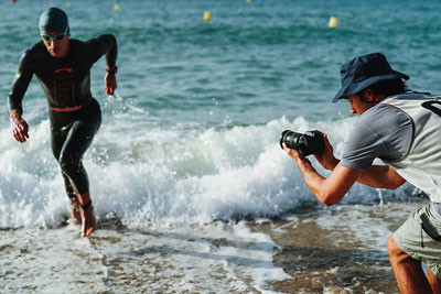someone taking a photo of someone running out of water using the sony a9 iii