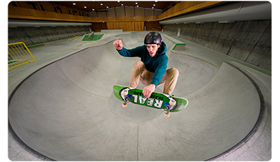 Sony FE 12-24mm F2.8 GM Lens sample photo of male skateboarder performing melon grab around round bowl ramp