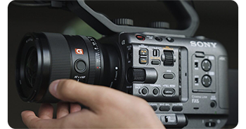 videographer adjusting focus on lens mounted on Sony FX6
