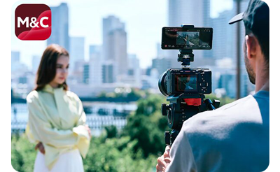 videographer using wireless Sony alpha camera and wireless monitoring on smartphone