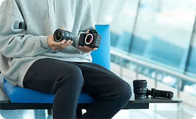someone attaching a lens to the sony zv e1 vlog camera