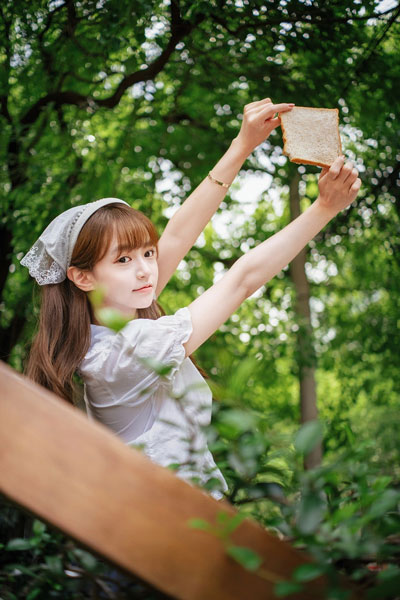 sample image of a woman holding a piece of bread taken using the ttartisan af lens