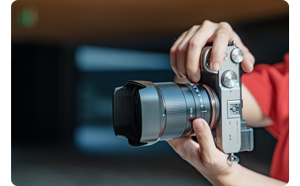 close up image of person holding sony camera with Ttartisan af 75mm lens attached