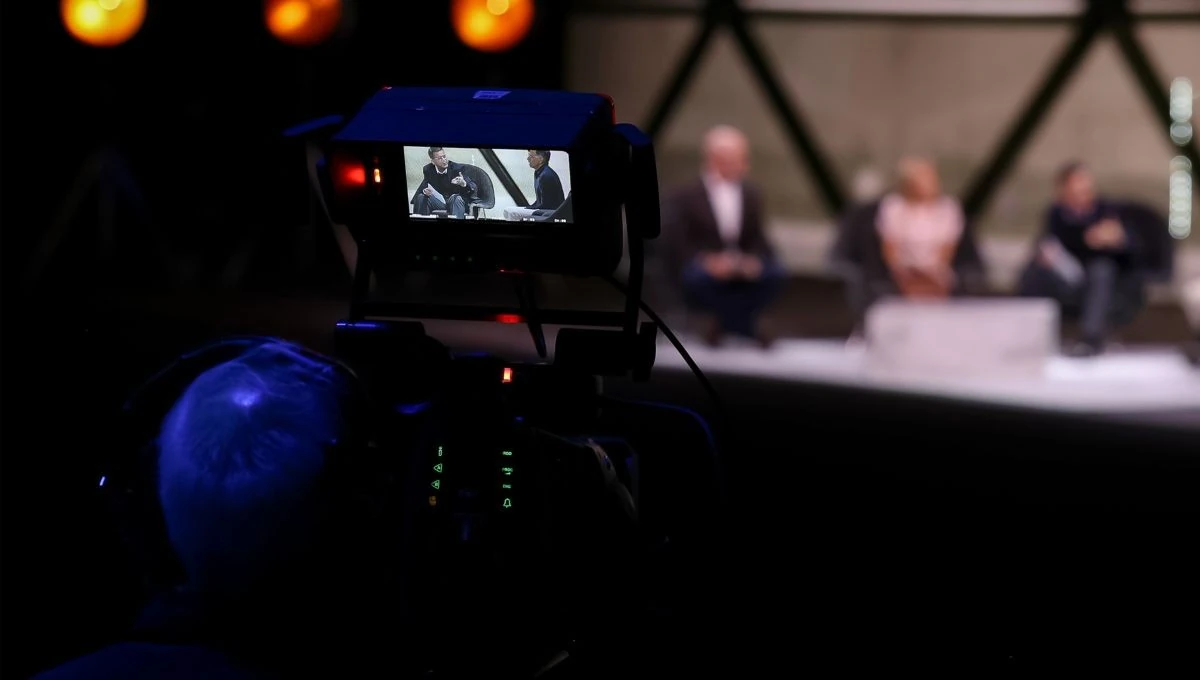 Television camera filming a panel discussion for a news broadcast