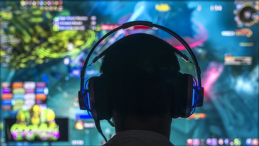 Photo of a man wearing headphones in front of a computer monitor