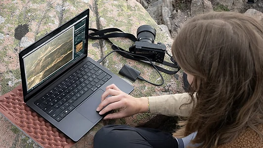 Person using a laptop outdoors with a Samsung T9 SSD connected